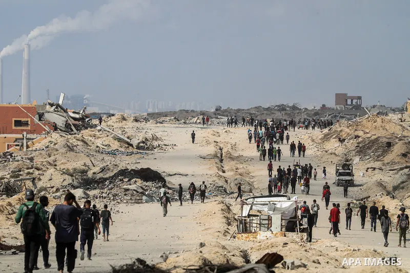 palestinians gather along the Coastal Road in the Al-Sudaniyya area in northern Gaza as they wait to receive humanitarian aid expected to enter through the Zikim crossing, on June 24, 2025 in Gaza. Long queues formed as...