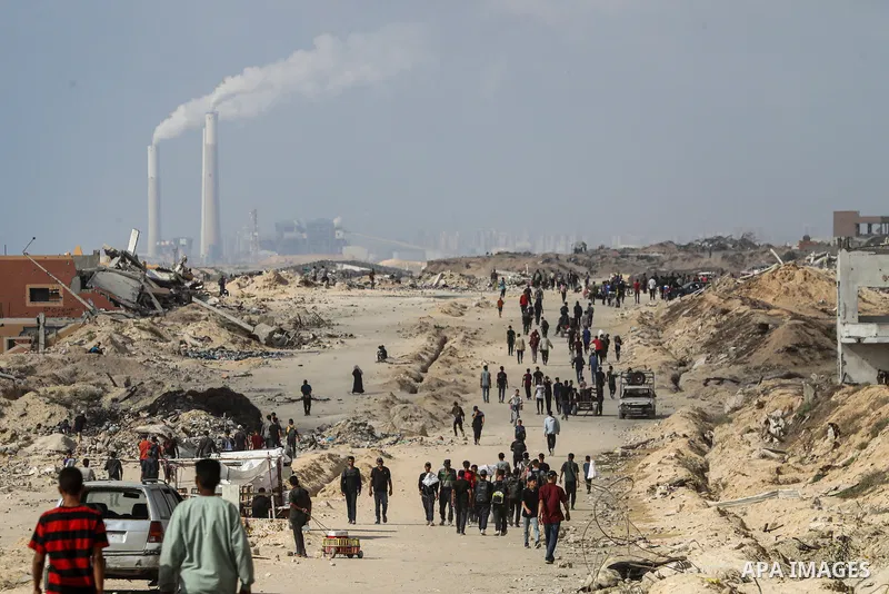 palestinians gather along the Coastal Road in the Al-Sudaniyya area in northern Gaza as they wait to receive humanitarian aid expected to enter through the Zikim crossing, on June 24, 2025 in Gaza. Long queues formed as...