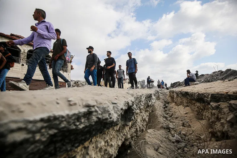 palestinians gather along the Coastal Road in the Al-Sudaniyya area in northern Gaza as they wait to receive humanitarian aid expected to enter through the Zikim crossing, on June 24, 2025 in Gaza. Long queues formed as...