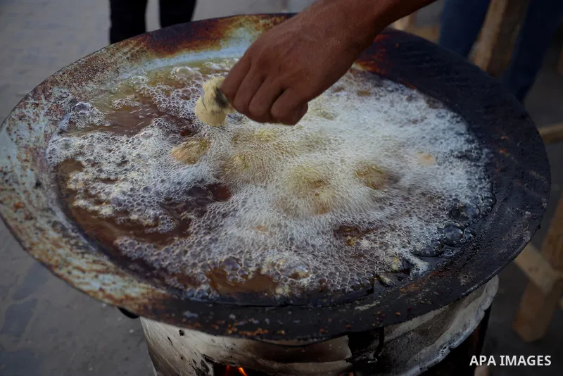Palestinians, deprived of basic necessities such as shelter, food, and clean water due to ongoing Israeli attacks, buy falafel from street vendors, as it is currently the most affordable and available food option amid se...