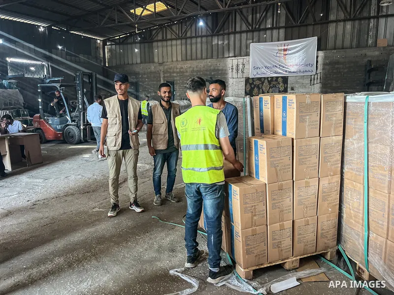 Palestinians receive food packages distributed by the World Food Programme (WFP) in the Zawaida area of Deir al-Balah in the central Gaza Strip following the implementation of the ceasefire on October 25, 2025. Photo by...