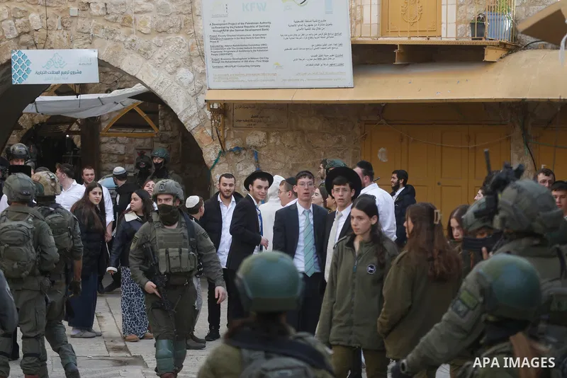 Israeli settlers, under the protection of Israeli forces, raid the Old City of Hebron in the southern West Bank on January 31, 2026. During the raid, Israeli soldiers were seen taking security measures in the area. Photo...