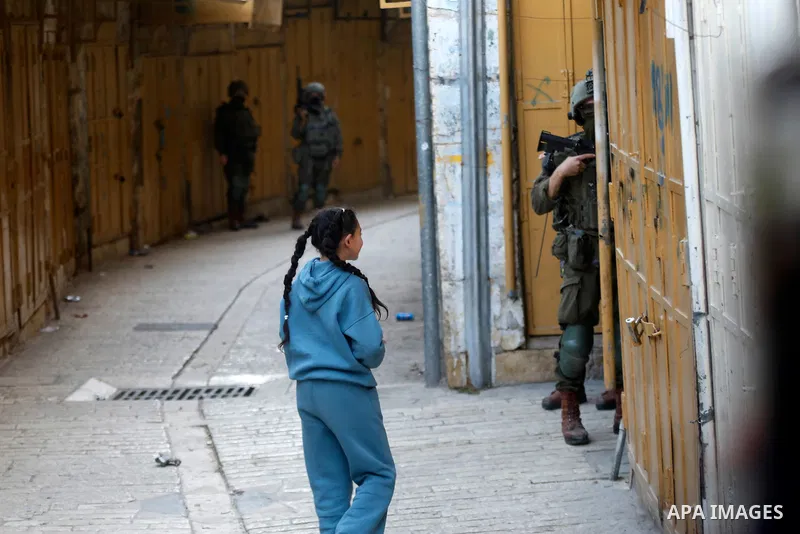Israeli settlers, under the protection of Israeli forces, raid the Old City of Hebron in the southern West Bank on January 31, 2026. During the raid, Israeli soldiers were seen taking security measures in the area. Photo...
