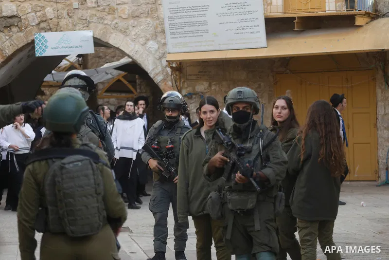 Israeli settlers, under the protection of Israeli forces, raid the Old City of Hebron in the southern West Bank on January 31, 2026. During the raid, Israeli soldiers were seen taking security measures in the area. Photo...