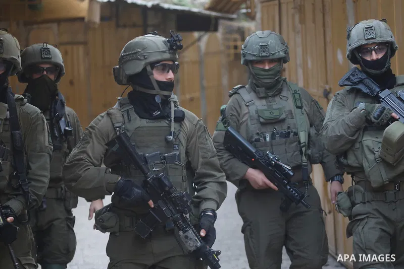 Israeli settlers, under the protection of Israeli forces, raid the Old City of Hebron in the southern West Bank on January 31, 2026. During the raid, Israeli soldiers were seen taking security measures in the area. Photo...