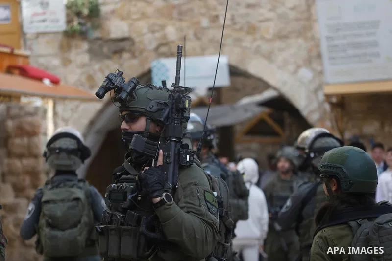 Israeli settlers, under the protection of Israeli forces, raid the Old City of Hebron in the southern West Bank on January 31, 2026. During the raid, Israeli soldiers were seen taking security measures in the area. Photo...