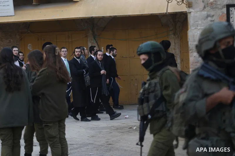 Israeli settlers, under the protection of Israeli forces, raid the Old City of Hebron in the southern West Bank on January 31, 2026. During the raid, Israeli soldiers were seen taking security measures in the area. Photo...