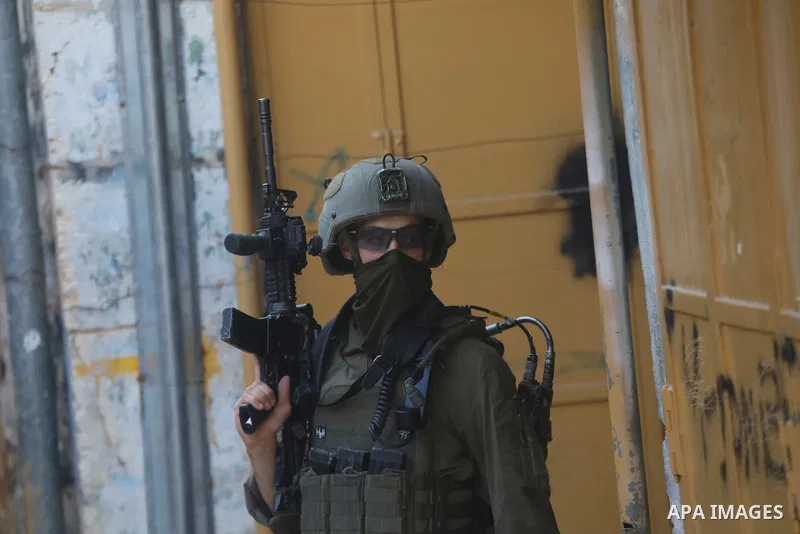 Israeli settlers, under the protection of Israeli forces, raid the Old City of Hebron in the southern West Bank on January 31, 2026. During the raid, Israeli soldiers were seen taking security measures in the area. Photo...