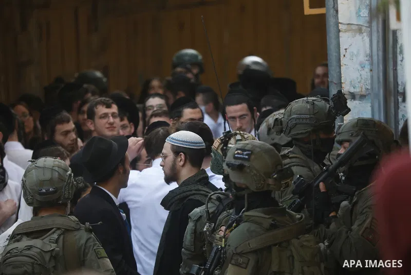 Israeli settlers, under the protection of Israeli forces, raid the Old City of Hebron in the southern West Bank on January 31, 2026. During the raid, Israeli soldiers were seen taking security measures in the area. Photo...