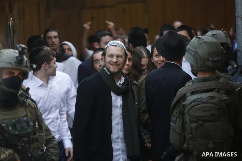 Israeli settlers, under the protection of Israeli forces, raid the Old City of Hebron in the southern West Bank on January 31, 2026. During the raid, Israeli soldiers were seen taking security measures in the area. Photo...