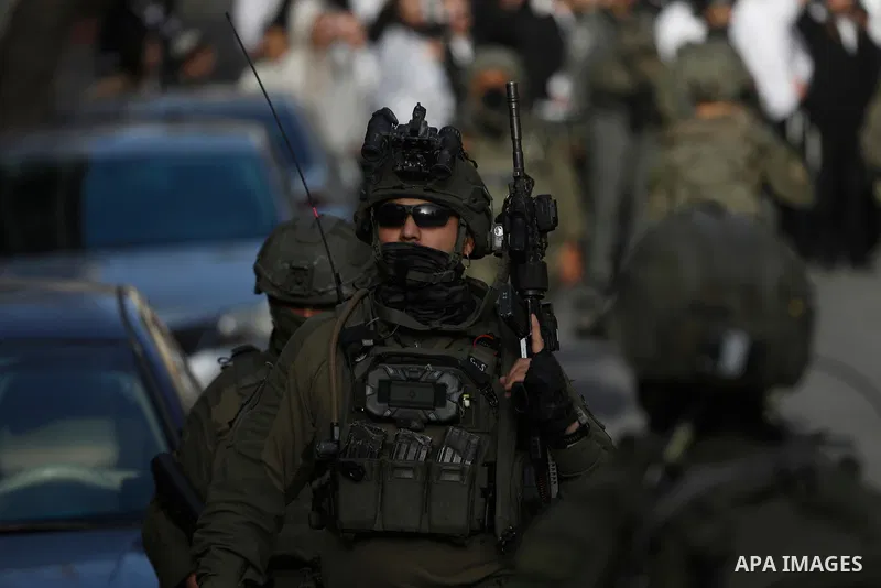 Israeli settlers, under the protection of Israeli forces, raid the Old City of Hebron in the southern West Bank on January 31, 2026. During the raid, Israeli soldiers were seen taking security measures in the area. Photo...