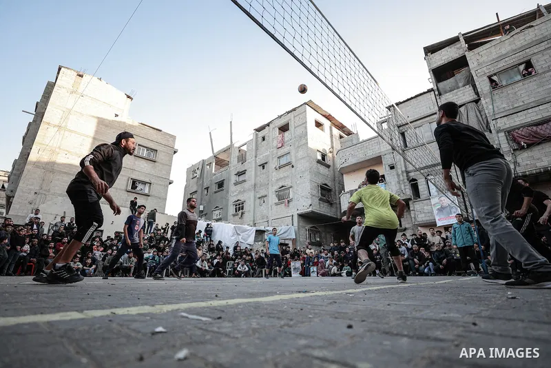 Palestinian Youth and children take part in volleyball matches as part of the so-called “Neighborhood League” at Bureij Refugee Camp, seeking to revive sporting activities after nearly two years of war, with the games of...