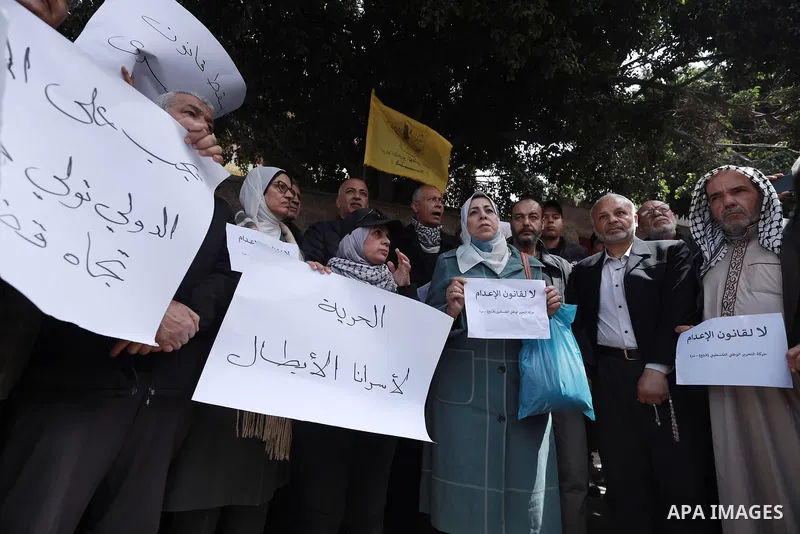 Palestinians participate in a demonstration to protest the Israeli Knesset's approval of a death penalty bill targeting Palestinian prisoners, carrying signs and chanting slogans condemning the legislation. Gaza City, Ap...