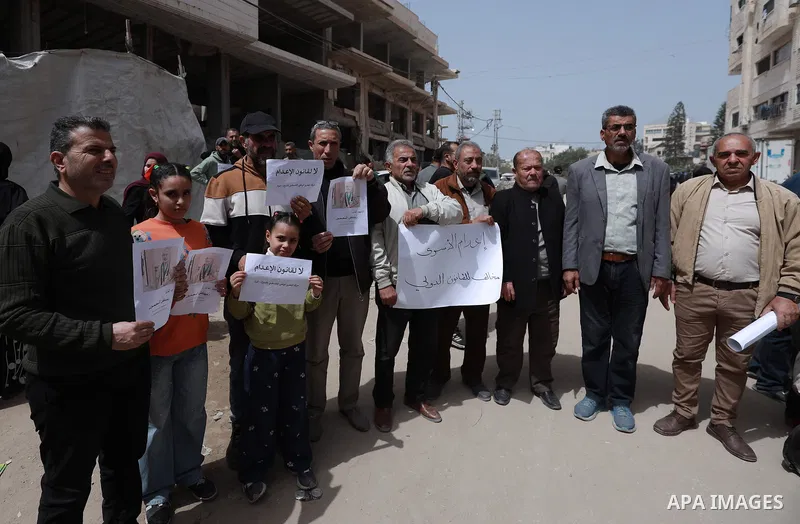 Palestinians participate in a demonstration to protest the Israeli Knesset's approval of a death penalty bill targeting Palestinian prisoners, carrying signs and chanting slogans condemning the legislation. Gaza City, Ap...