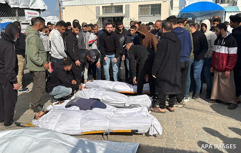 Mourners gather around the bodies of Palestinians, who according to medics were killed in an overnight Israeli strike, at Al-Aqsa Martyrs Hospital in Deir el-Balah, central Gaza Strip on April 11, 2026. Hundreds of thous...