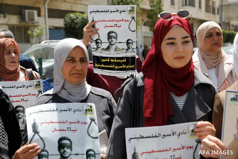 Palestinian demonstrators hold pictures of prisoners held in Israeli jails, including jailed Palestinian leader Marwan Barghouti, during a rally in the occupied West Bank city of Hebron on April 16, 2026 to mark Prisoner...