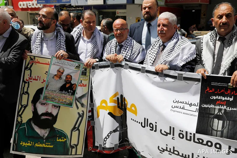 Palestinian demonstrators hold pictures of prisoners held in Israeli jails, including jailed Palestinian leader Marwan Barghouti, during a rally in the occupied West Bank city of Hebron on April 16, 2026 to mark Prisoner...