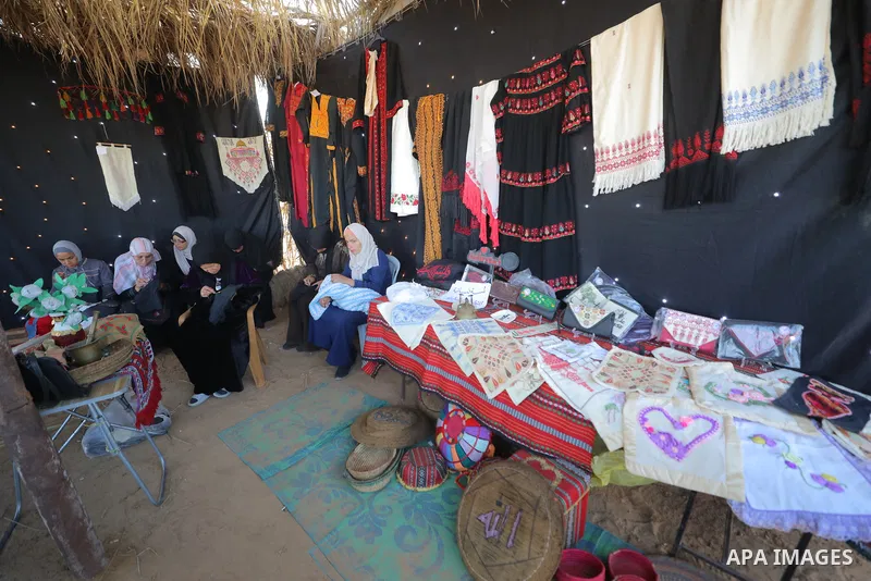 Displaced Palestinians take part in a popular event marking International Workers' Day inside a shelter center in al-Maghazi camp in the central Gaza Strip, on May 1, 2026. The event included Palestinian heritage perform...