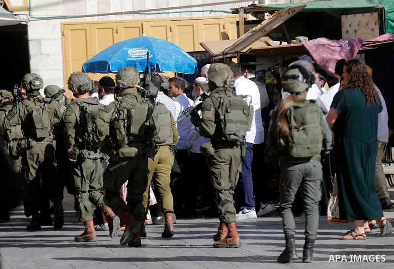 Israeli settlers walk through the Old City of Hebron in the occupied West Bank on May 16, 2026, during a tour conducted under the protection of Israeli forces deployed around the entrances and historic market areas. The...