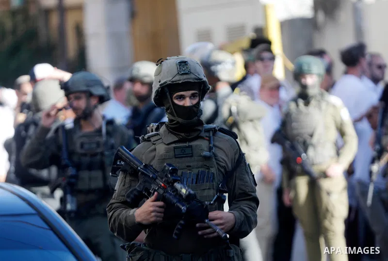 Israeli settlers walk through the Old City of Hebron in the occupied West Bank on May 16, 2026, during a tour conducted under the protection of Israeli forces deployed around the entrances and historic market areas. The...