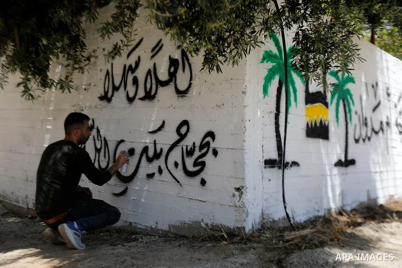 A Palestinian calligrapher paints congratulatory messages along with religious and traditional motifs on the wall of a pilgrim’s home in the West Bank city of Hebron on May 31, 2026, ahead of the pilgrim’s return from pe...