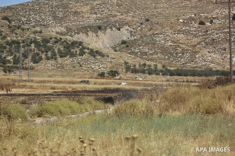 Palestinians and members of the Palestinian Civil Defense gather near the site of a fire on agricultural land around the village of Idhna, west of the West Bank city of Hebron, on June 2, 2026. Palestinian residents said...