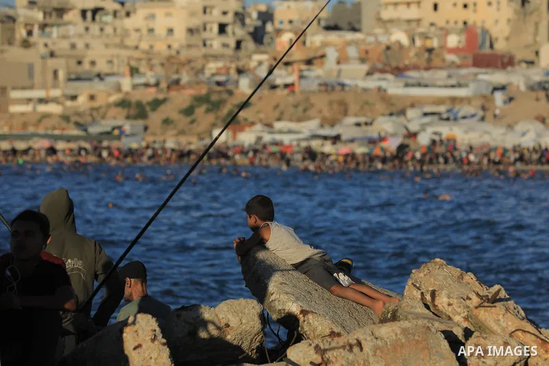 Palestinians gather along the beach at the Gaza City on June 5, 2026, during hot weather conditions. Despite a truce technically in effect since October 2025, daily violence has continued across the Gaza Strip, more than...