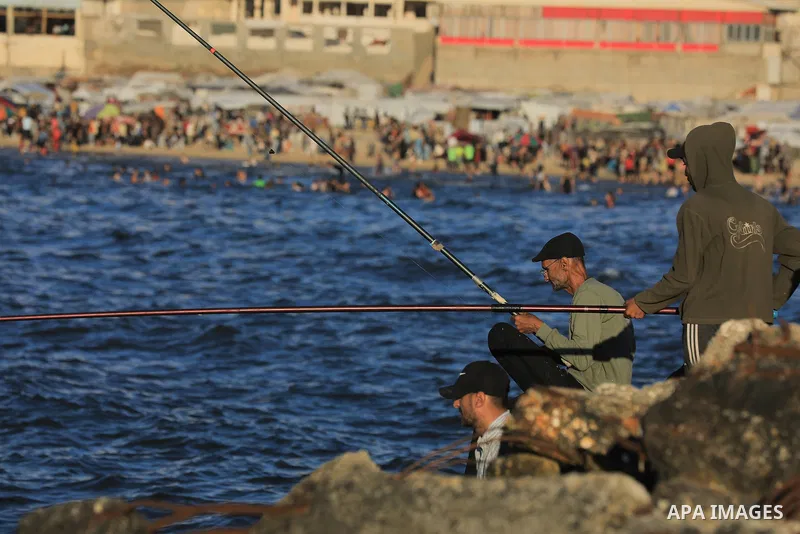 Palestinians gather along the beach at the Gaza City on June 5, 2026, during hot weather conditions. Despite a truce technically in effect since October 2025, daily violence has continued across the Gaza Strip, more than...