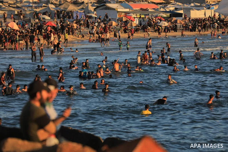 Palestinians gather along the beach at the Gaza City on June 5, 2026, during hot weather conditions. Despite a truce technically in effect since October 2025, daily violence has continued across the Gaza Strip, more than...