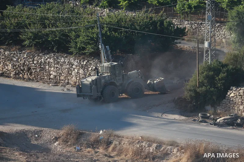 Israeli army vehicles place earth mounds and concrete blocks at roads and entrances to the town of Beit Ummar, north of Hebron in the occupied West Bank, on June 9, 2026. According to local sources, Israeli forces have c...