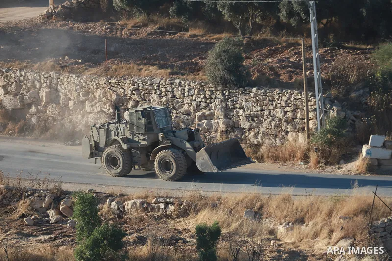 Israeli army vehicles place earth mounds and concrete blocks at roads and entrances to the town of Beit Ummar, north of Hebron in the occupied West Bank, on June 9, 2026. According to local sources, Israeli forces have c...