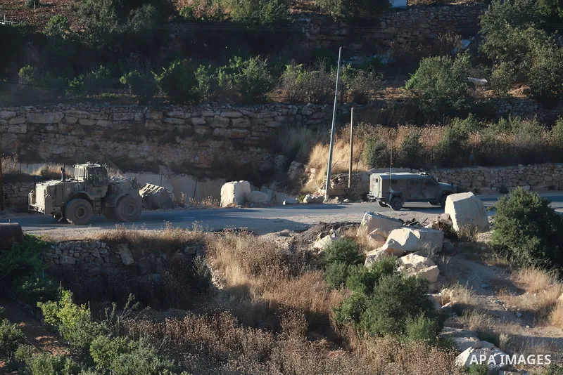 Israeli army vehicles place earth mounds and concrete blocks at roads and entrances to the town of Beit Ummar, north of Hebron in the occupied West Bank, on June 9, 2026. According to local sources, Israeli forces have c...