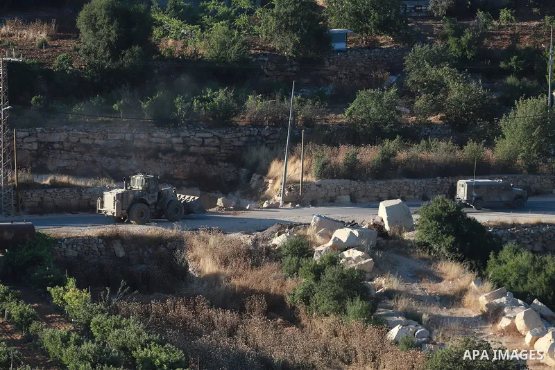 Israeli army vehicles place earth mounds and concrete blocks at roads and entrances to the town of Beit Ummar, north of Hebron in the occupied West Bank, on June 9, 2026. According to local sources, Israeli forces have c...