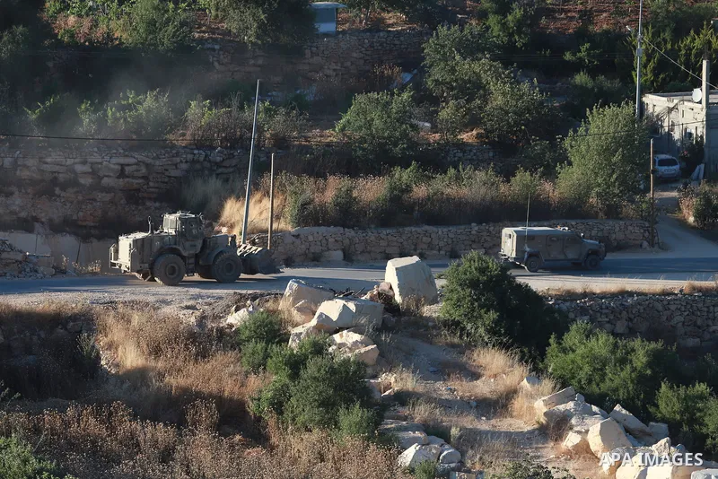 Israeli army vehicles place earth mounds and concrete blocks at roads and entrances to the town of Beit Ummar, north of Hebron in the occupied West Bank, on June 9, 2026. According to local sources, Israeli forces have c...