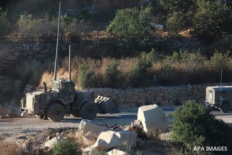 Israeli army vehicles place earth mounds and concrete blocks at roads and entrances to the town of Beit Ummar, north of Hebron in the occupied West Bank, on June 9, 2026. According to local sources, Israeli forces have c...