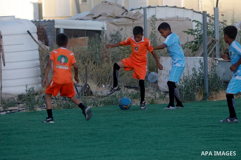 Children hold placards at a playground threatened with demolition in the village of Umm al-Khair, south of Hebron in the West Bank, on June 11, 2026. The children sent a message to FIFA at the start of the World Cup, cal...