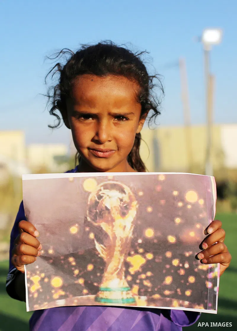 Children hold placards at a playground threatened with demolition in the village of Umm al-Khair, south of Hebron in the West Bank, on June 11, 2026. The children sent a message to FIFA at the start of the World Cup, cal...