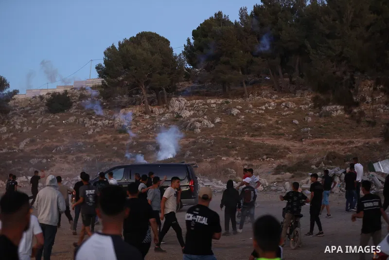 Palestinians run for cover as Israeli forces fire tear gas canisters toward visitors at the historic Solomon’s Pools area, south of Bethlehem in the occupied West Bank, on June 12, 2026. The incident occurred while peopl...
