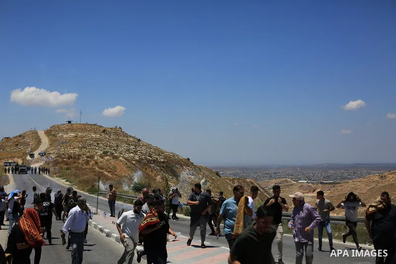 Palestinians gather during a protest against the confiscation of land for settlement expansion near Jabal Tarousa in the town of Dura, south of Hebron in the West Bank, on June 19, 2026. Israeli forces fired tear gas to...