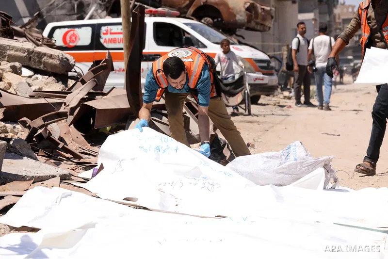 Members of the Palestinian Civil Defense and relatives of victims take part in the transfer of human remains from Sheikh Radwan Cemetery in Gaza City on June 23, 2026. The Civil Defense said the remains belonged to dozen...