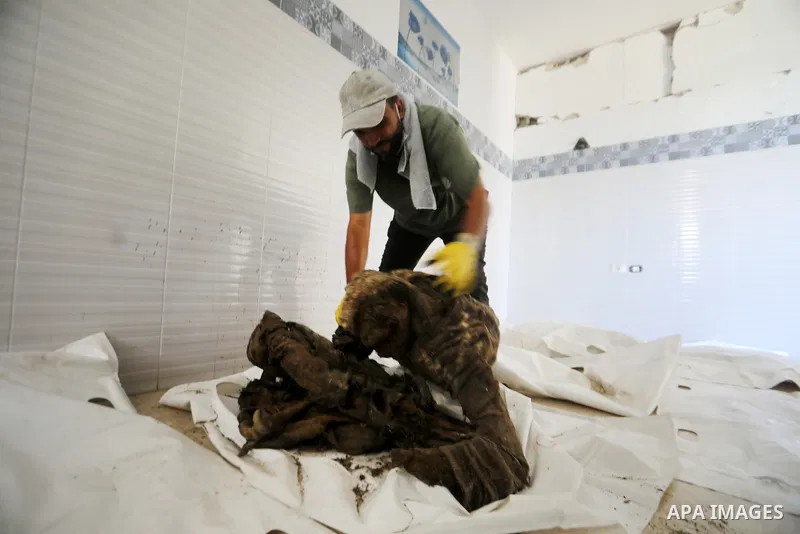 A Palestinian man attempts to identify human remains recovered from beneath the rubble of destroyed buildings during the second phase of search and recovery operations carried out by the Palestinian Civil Defense in the...