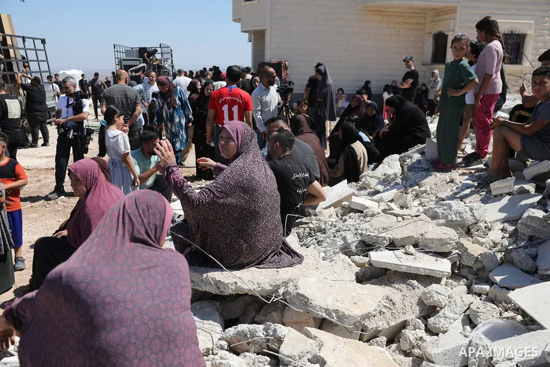 Palestinians sit on the rubble of a home demolished by Israeli forces in the town of Beit Awa, south of Hebron, in the occupied West Bank, on July 20, 2026. The house belonged to Ahmad Masalma, whose family inspected the...