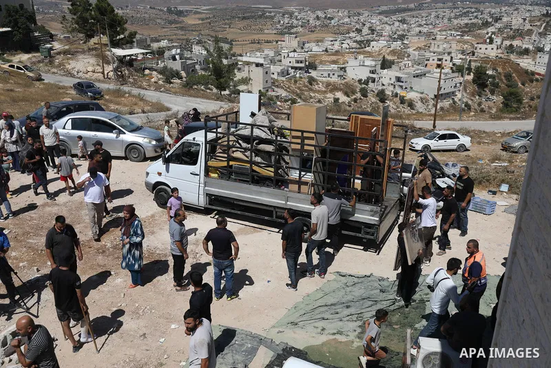 Palestinians sit on the rubble of a home demolished by Israeli forces in the town of Beit Awa, south of Hebron, in the occupied West Bank, on July 20, 2026. The house belonged to Ahmad Masalma, whose family inspected the...