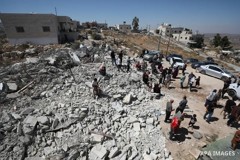 Palestinians sit on the rubble of a home demolished by Israeli forces in the town of Beit Awa, south of Hebron, in the occupied West Bank, on July 20, 2026. The house belonged to Ahmad Masalma, whose family inspected the...