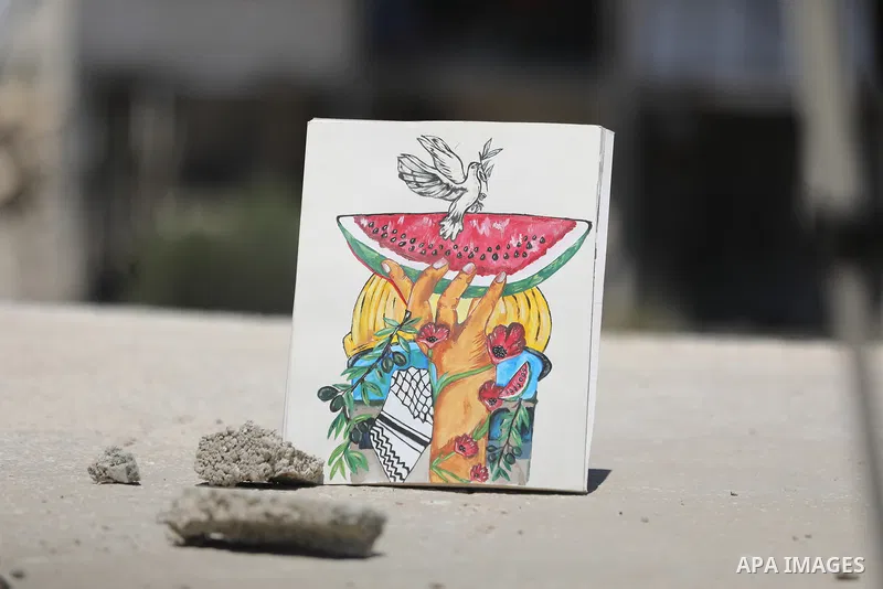Palestinian visual artist Jana Mahmoud Abu Harbid, 21, paints on the roof of her family's damaged home after returning to northern Gaza and finding her studio destroyed following the war, in Gaza City, on July 20, 2026....