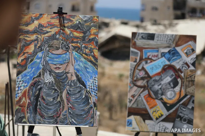 Palestinian visual artist Jana Mahmoud Abu Harbid, 21, paints on the roof of her family's damaged home after returning to northern Gaza and finding her studio destroyed following the war, in Gaza City, on July 20, 2026....