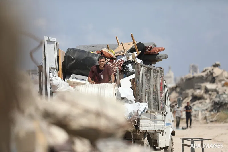 Displaced Palestinians carry their belongings as they flee the Dawla area near Salah al-Din Street in the Zeitoun neighborhood of Gaza City, on July 22, 2026, after the Israeli army advanced concrete barriers locally kno...