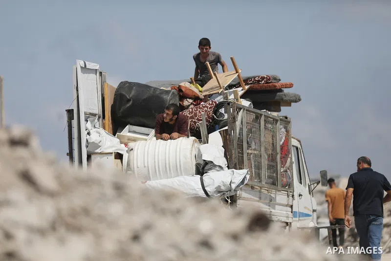 Displaced Palestinians carry their belongings as they flee the Dawla area near Salah al-Din Street in the Zeitoun neighborhood of Gaza City, on July 22, 2026, after the Israeli army advanced concrete barriers locally kno...