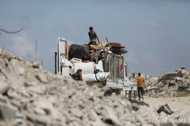 Displaced Palestinians carry their belongings as they flee the Dawla area near Salah al-Din Street in the Zeitoun neighborhood of Gaza City, on July 22, 2026, after the Israeli army advanced concrete barriers locally kno...
