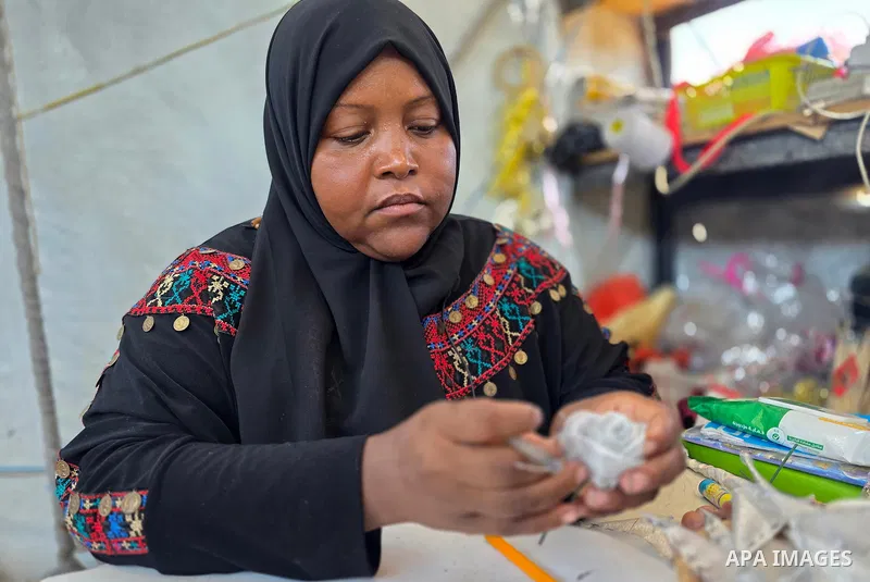 Displaced Palestinian Shireen Nassar prepares wedding supplies inside her tent in the al-Mawasi area, west of Khan Younis, southern Gaza Strip, on July 22, 2026. Nassar has transformed the tent into both a workspace and...